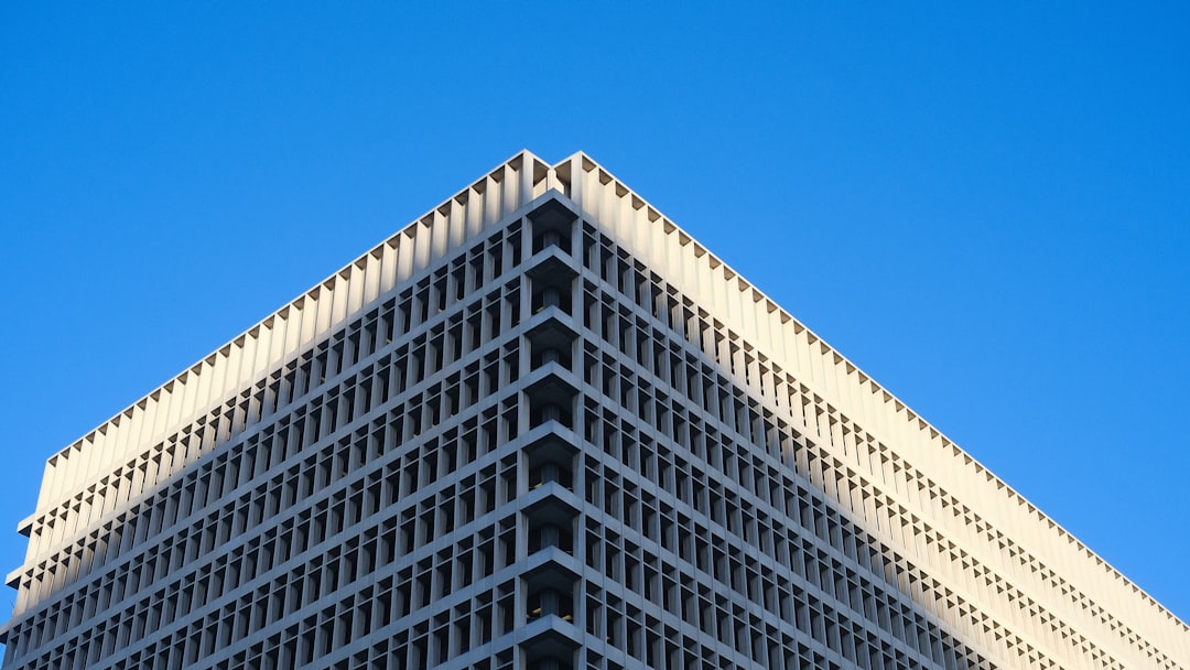 무선 이어폰, 사기 전에 알았으면 좋았을 것 Modern office building against a clear blue sky